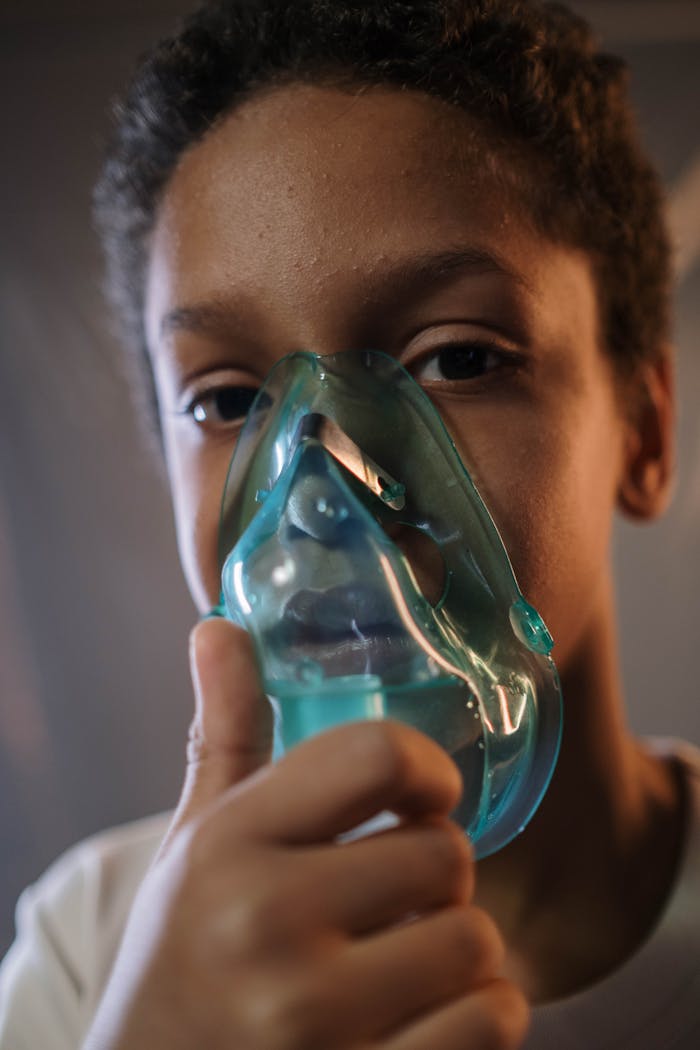 A child using an inhaler for medical treatment, emphasizing health care.